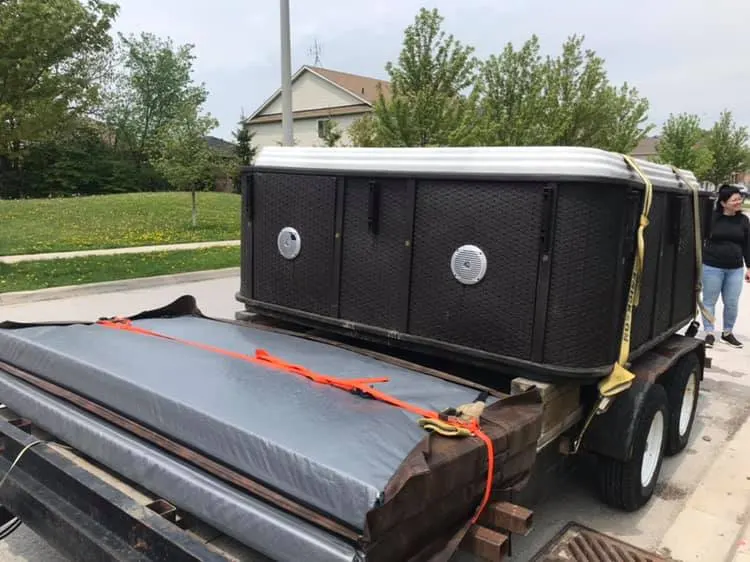 Hot tub strapped on a trailer for removal